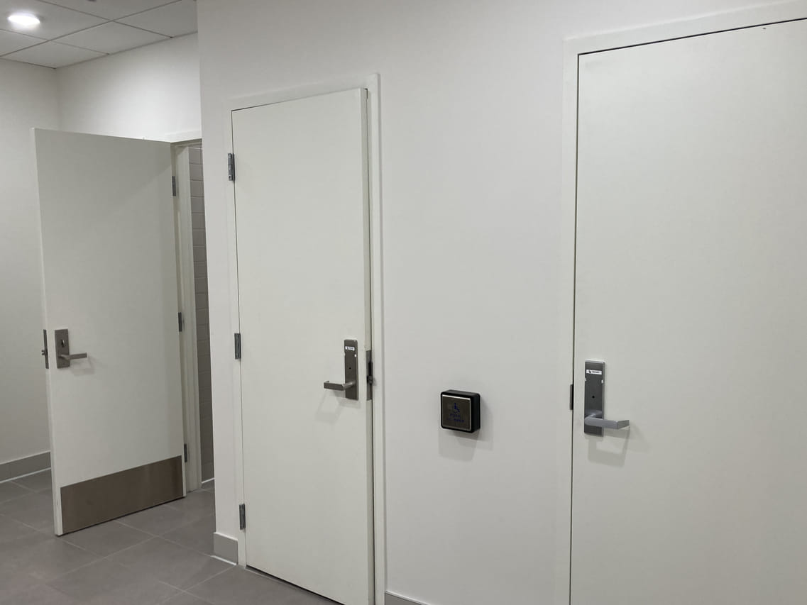 3 stall doors in bathroom that close completely like a room.